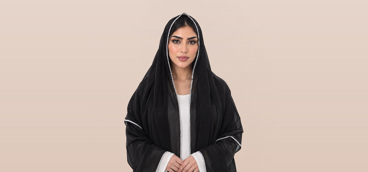 امرأة تلبس شيلة ليال السوداء بشغل أبيض على أطرافها، LL-03
