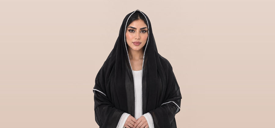امرأة تلبس شيلة ليال السوداء بشغل أبيض على أطرافها، LL-03
